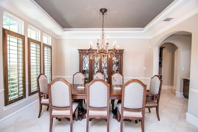 14115 Woodthorpe Ln, Houston, TX 77079 - dining room featuring a chandelier, arched walkways, a raised ceiling, crown molding, and baseboards