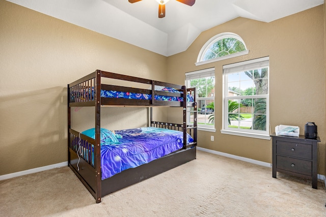 carpeted bedroom featuring baseboards, lofted ceiling, and a ceiling fan