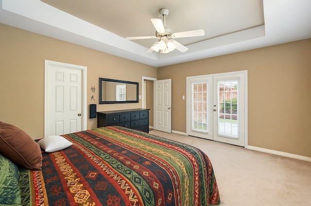 bedroom with access to outside, light colored carpet, baseboards, and a raised ceiling