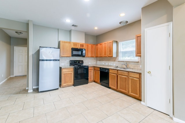 kitchen featuring black appliances, a sink, backsplash, light stone countertops, and light tile patterned floors