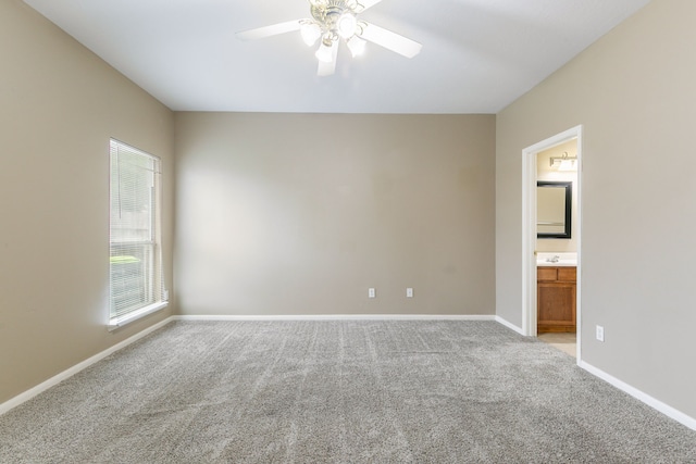 unfurnished bedroom with light carpet, baseboards, and connected bathroom