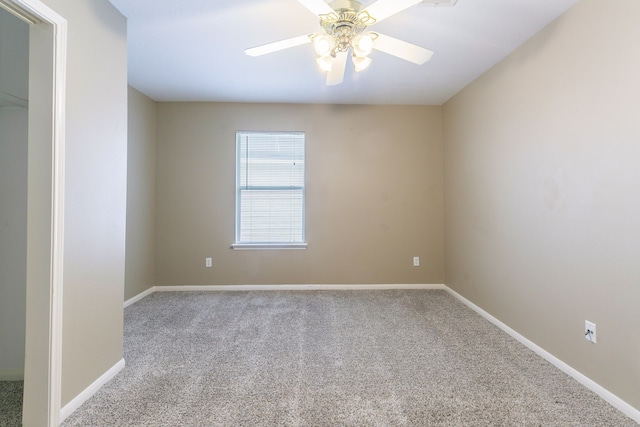 carpeted empty room with a ceiling fan and baseboards
