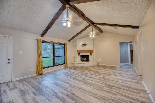 4650 Hickory Downs Dr, Houston, TX 77084 - unfurnished living room featuring a ceiling fan, a textured ceiling, light wood-type flooring, a brick fireplace, and baseboards