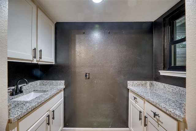 4650 Hickory Downs Dr, Houston, TX 77084 - clothes washing area featuring a sink and a textured wall