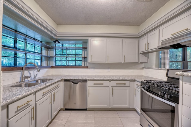 4650 Hickory Downs Dr, Houston, TX 77084 - kitchen with stainless steel appliances, a sink, plenty of natural light, a textured ceiling, and light tile patterned floors