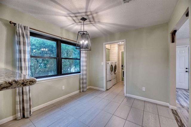 4650 Hickory Downs Dr, Houston, TX 77084 - unfurnished dining area with washing machine and dryer, a chandelier, a textured ceiling, light tile patterned flooring, and baseboards