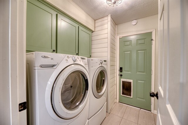 4650 Hickory Downs Dr, Houston, TX 77084 - laundry room with cabinet space, washer and clothes dryer, a textured ceiling, and light tile patterned floors