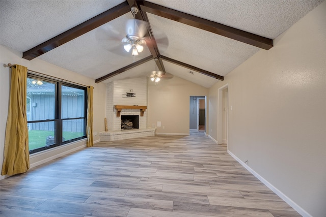 4650 Hickory Downs Dr, Houston, TX 77084 - unfurnished living room with a ceiling fan, light wood-type flooring, a fireplace, baseboards, and a textured ceiling