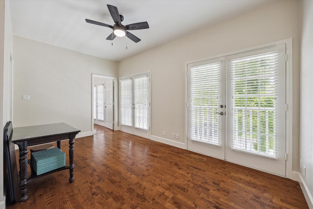 empty room featuring plenty of natural light, ceiling fan, wood finished floors, and baseboards