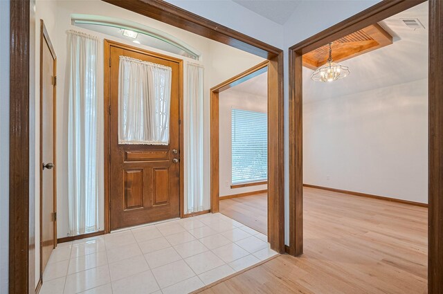 16218 Capri Dr, Jersey Village, TX 77040 - foyer with a chandelier, light wood finished floors, and baseboards