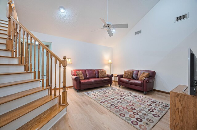 16218 Capri Dr, Jersey Village, TX 77040 - living area featuring wood finished floors, stairs, ceiling fan, baseboards, and high vaulted ceiling