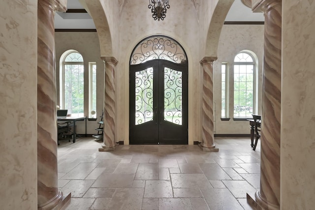 26118 Upper Beacon Pl, Montgomery, TX 77316 - foyer entrance with decorative columns, arched walkways, stone tile floors, and ornamental molding