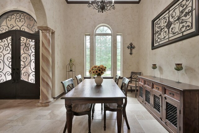 26118 Upper Beacon Pl, Montgomery, TX 77316 - dining area with stone tile floors, a chandelier, french doors, ornate columns, and a towering ceiling