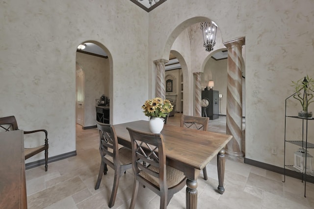 26118 Upper Beacon Pl, Montgomery, TX 77316 - dining room featuring arched walkways, stone tile floors, baseboards, and ornate columns