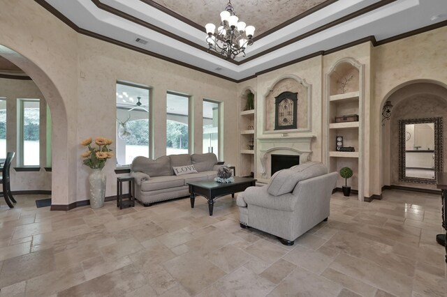 26118 Upper Beacon Pl, Montgomery, TX 77316 - living room featuring built in shelves, stone tile floors, crown molding, a tray ceiling, and arched walkways
