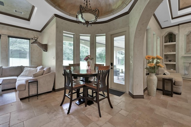 26118 Upper Beacon Pl, Montgomery, TX 77316 - dining area with ornamental molding, a tray ceiling, stone tile flooring, baseboards, and arched walkways