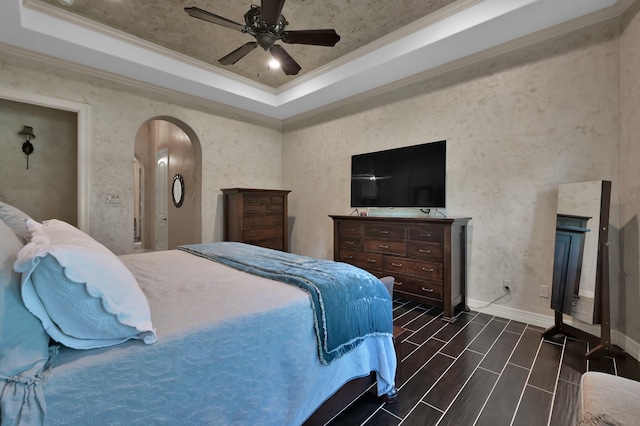 26118 Upper Beacon Pl, Montgomery, TX 77316 - bedroom featuring a raised ceiling, arched walkways, crown molding, wood finish floors, and baseboards