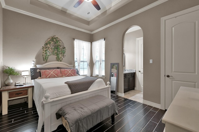 26118 Upper Beacon Pl, Montgomery, TX 77316 - bedroom featuring a tray ceiling, arched walkways, wood tiled floors, crown molding, and baseboards