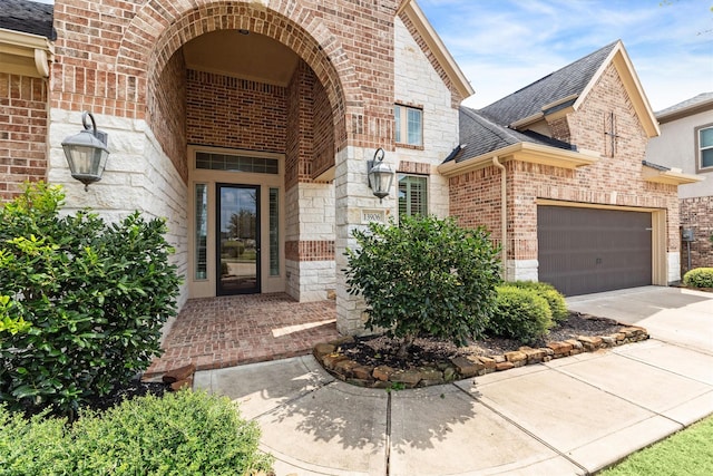 13906 Bell Valley Ct, Houston, TX 77059 - property entrance featuring brick siding, stone siding, a shingled roof, driveway, and a garage