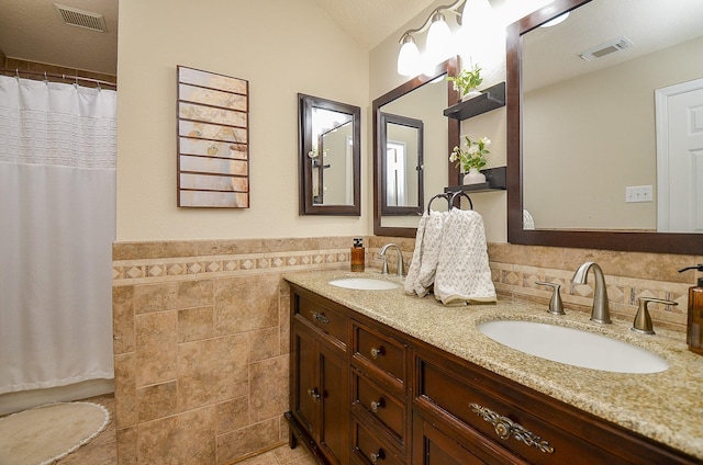 14411 Lawton Ridge Dr, Cypress, TX 77429 - full bathroom with tile walls, double vanity, wainscoting, tile patterned floors, and vaulted ceiling