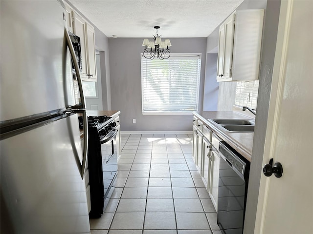 kitchen featuring freestanding refrigerator, range with gas cooktop, dishwashing machine, a sink, and white cabinets