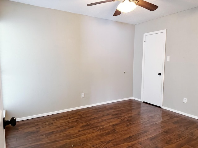 unfurnished room featuring dark wood-style flooring, ceiling fan, and baseboards