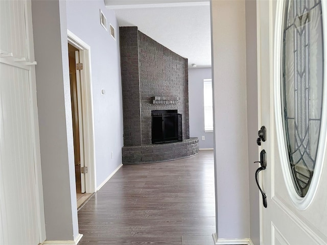 entryway featuring wood finished floors, a fireplace, and baseboards