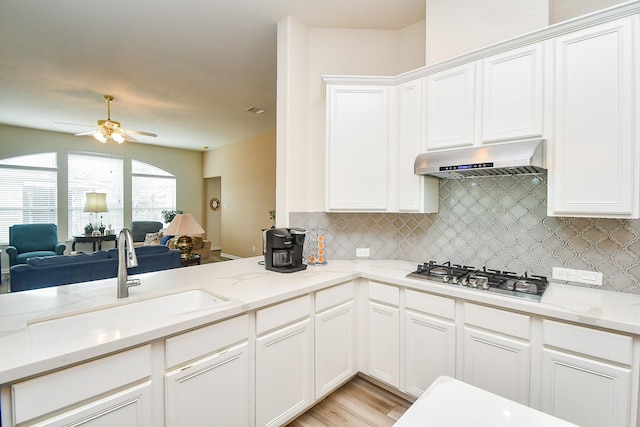 15203 Cypress Post Ln, Cypress, TX 77429 - kitchen featuring stainless steel gas cooktop, extractor fan, a sink, open floor plan, and a ceiling fan