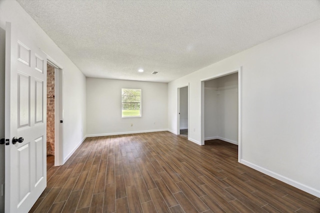 20576 Kings Rd, New Caney, TX 77357 - unfurnished bedroom featuring dark wood-style floors, a textured ceiling, and a closet