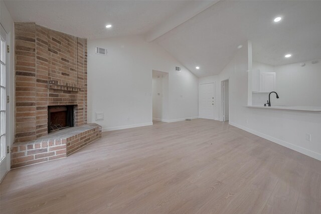 16250 Rancho Blanco Dr, Houston, TX 77083 - unfurnished living room with light wood-style floors, a fireplace, baseboards, a sink, and recessed lighting
