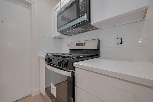 16250 Rancho Blanco Dr, Houston, TX 77083 - kitchen featuring appliances with stainless steel finishes, light countertops, decorative backsplash, and white cabinets