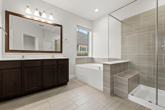 full bath with a stall shower, a garden tub, double vanity, and recessed lighting