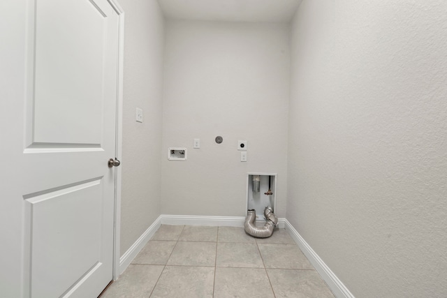 clothes washing area with electric dryer hookup, baseboards, washer hookup, and light tile patterned floors