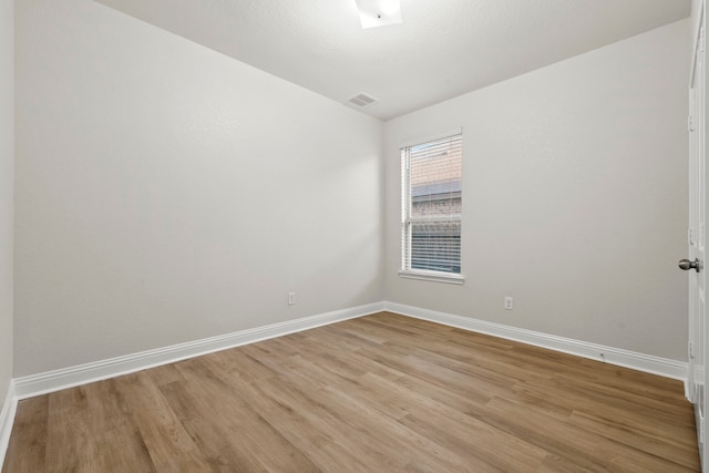 unfurnished room with light wood-style flooring, baseboards, and vaulted ceiling