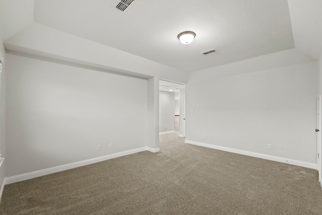 unfurnished room with carpet floors, baseboards, and a textured ceiling