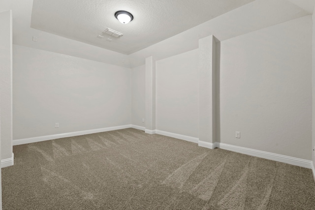 carpeted spare room featuring baseboards and a textured ceiling