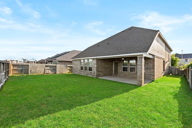 rear view of house featuring brick siding, a patio, and a shingled roof