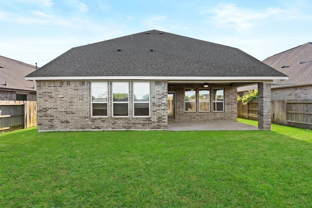 back of property featuring brick siding, a patio area, and roof with shingles
