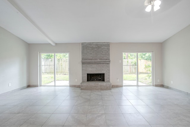 5102 Enchanted Timbers Dr, Humble, TX 77346 - unfurnished living room featuring healthy amount of natural light, a brick fireplace, light tile patterned flooring, beam ceiling, and a ceiling fan