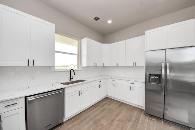 11141 Rd 5503, Cleveland, TX 77327 - kitchen featuring stainless steel appliances, a sink, backsplash, white cabinets, and light stone counters
