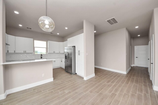 11141 Rd 5503, Cleveland, TX 77327 - kitchen featuring stainless steel fridge with ice dispenser, light countertops, a peninsula, baseboards, and decorative backsplash