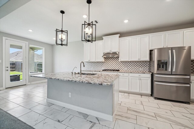 2641 Summer Indigo Trl, Pearland, TX 77089 - kitchen featuring stainless steel appliances, light marble finish floors, a chandelier, light stone countertops, and white cabinetry