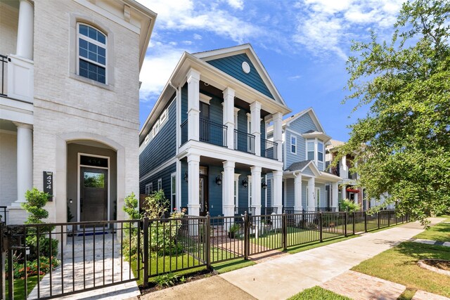 436 W 26th St, Houston, TX 77008 - view of front of home with a porch, a balcony, a fenced front yard, a gate, and brick siding