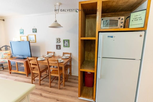 6300 Seawall Blvd Unit 9228, Galveston, TX 77551 - kitchen with freestanding refrigerator, light wood-type flooring, and decorative light fixtures