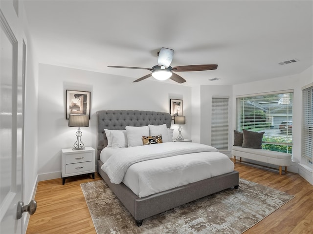 bedroom with light wood finished floors, ceiling fan, and baseboards