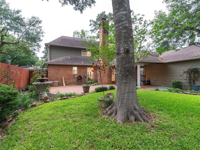 back of house with a patio area, a chimney, and brick siding