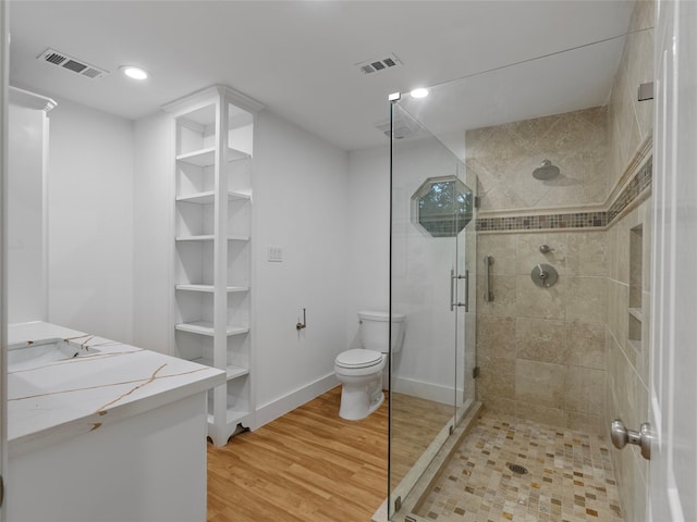 full bathroom featuring a shower stall, wood finished floors, toilet, recessed lighting, and vanity
