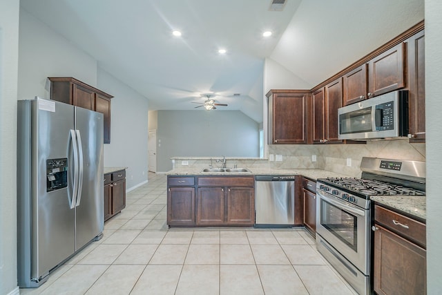 16702 Peralta Bay Cir, Crosby, TX 77532 - kitchen with appliances with stainless steel finishes, a sink, vaulted ceiling, decorative backsplash, and a ceiling fan