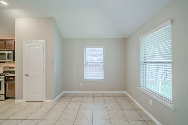 16702 Peralta Bay Cir, Crosby, TX 77532 - empty room featuring light tile patterned floors, vaulted ceiling, and baseboards