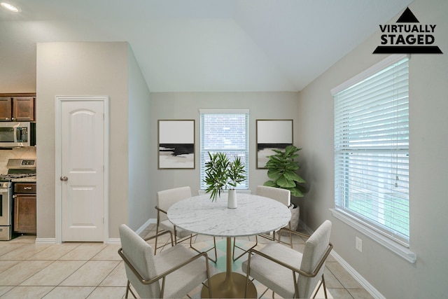 16702 Peralta Bay Cir, Crosby, TX 77532 - dining space featuring light tile patterned flooring, healthy amount of natural light, vaulted ceiling, and baseboards